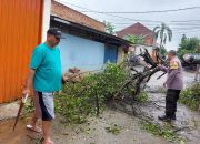Bhabinkamtibmas Polsek Legok Bantu Warga Memotong Pohon Tumbang yang Menutupi Jalan